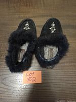 Pair of black Manitobah Mukluks moccasins top view showing beadwork decoration and fur trim.