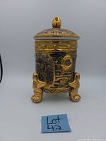 Front view of the vintage Satsuma covered urn showing detailed hand-painted designs, gold accents, and the lid with a gold finial.