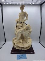 Full front view of the detailed sculpture showing the woman holding the two dogs on leashes.