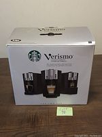 Front view of boxed Starbucks Verismo 600 coffee machine showing logo and images of the machine