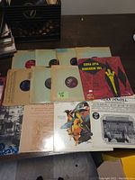 Photo showing several 78 RPM records in paper sleeves alongside various LP album covers with classical and popular music art.