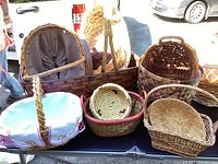 Front view of the baskets showing a variety of sizes and shapes including picnic baskets, coiled baskets, and a football-shaped basket.
