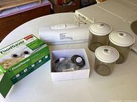 Overview of all items including vacuum sealer, packaging rolls box, canisters, and accessories.