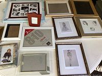 Overview of the lot showing various picture frames in different styles and sizes on a white surface.