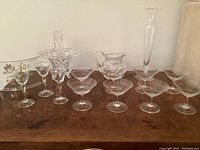 Full view of various German cut crystal stemware in Keil Schliff pattern with pitcher, bud vase and floral curved glass.
