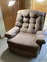 Front view of taupe Lane recliner chair showing cushioned tufted backrest and padded armrests.