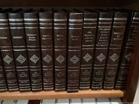 Close-up photo showing the spines of several volumes including Homer, Shakespeare, Marlowe Shakespeare, Pamour Puffaces, Milton Poems, Edmund Burke, The Thousand and One Nights, and others from the Harvard Classics Collector's Edition.