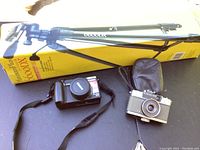 Lot contents including Canon PowerShot G5, Olympus Pen camera with case, Platinum Plus 6600 DX tripod box and tripod, photo organizer cases