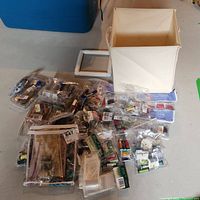 Overview of all bead packs, floss skeins, storage box and frame stand scattered on floor