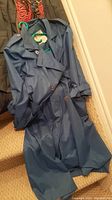 Blue London Fog trench coat hanging on stairs