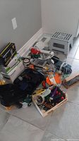 Full view of lot including step stool, hardware, light bulbs, power cords, calculator, and boxed items.