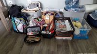 Wide shot showing all knitting supplies including bags, baskets, and bins with yarn and patterns
