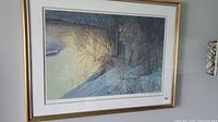 Full view of framed print hanging on wall, showing gold-toned frame and white mat around Siberian tiger image.