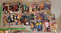 Top view of a large assortment of Spider-Man and Venom comics arranged side by side showing issue numbers and colorful covers.
