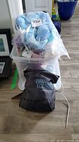 Clear plastic tote filled with sealed yarn skeins and River City Yarns bag