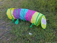 Pop up caterpillar in colorful stripes with caterpillar face and fabric feet on grass.