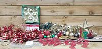 Overview of multiple Christmas decorations including garlands, ornaments, strands of lights, and tree topper.