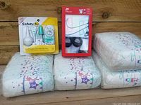 Photo showing four packages of Parent's Choice size 3 diapers, Safety 1st Healthcare On-the-Go Kit, and Nike infant outfit in package.