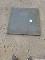 Gray solid plastic pallet with a flat top surface placed on concrete floor, dimensions 36x36x2 inches, lightly used with visible wear marks.