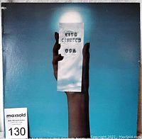 Front cover showing hand holding paper with 'KING CRIMSON USA' text, blue background.