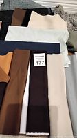 Fabric samples in assorted textures and colors, mostly solid colors with some patterned pieces.