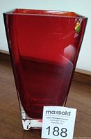 Front view of the red Murano glass vase showing the block cut style and clear thick base.
