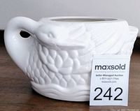 White ceramic swan-shaped planter with detailed textured feathers and wings visible, showing overall condition and design.