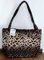 Photo showing the front of the cheetah print tote bag with long handles against a white background.