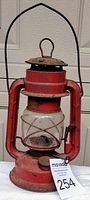 Full view of red oil lantern showing overall shape and handle