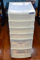 Front view of 6 drawer plastic storage organizer showing translucent drawers and flat top lid compartment.