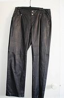 Front view of black leather pants showing front pockets, belt loops, and closure details.