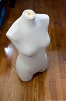 Photo showing front view of female mannequin torso with fabric cover and neck mounting area.