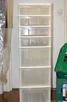 Full view of the tall plastic storage unit with six clear drawers, three are peg-board style for thread storage
