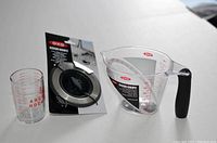 All three kitchen items: Oxo measuring cup, Oxo sink strainer and stopper, Anchor small measuring cup