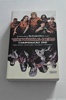 Front cover of The Walking Dead Compendium One softcover graphic novel showing characters and zombies artwork.