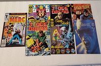 Front view of lot showing seven 1980s comic books lying flat including Marvel's Merc, two Judge Dredd issues, Star Trek, Carlock, and Sam Slade Robo Hunter.