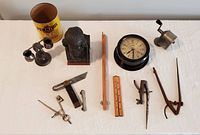 Photo showing the collection of miscellaneous antique items including the toothpick holder, Penzoil tin, clock, and various tools.