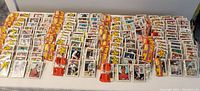 Wide view of 49 unopened 1988 Topps Rak Pak baseball card packs laid out showing variety and quantity