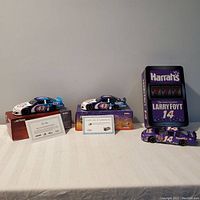 Photo showing the three NASCAR diecast cars with their display boxes and certificates of authenticity for two cars.