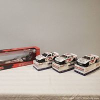 Four 1/24 scale Snap-On Tools NASCAR die-cast models, including three stock cars on original boxes and one dragster in original packaging, displayed on a white surface.