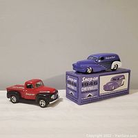Two Snap-on Tools 1/25 scale diecast collectible toy trucks, one red pickup truck, one purple and white 1946 Chevrolet sedan delivery truck displayed on original box