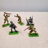 Five DeeTail vintage toy soldier figurines on a white background with clear details of paint and poses.