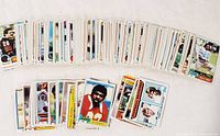 Wide layout of the football card collection spread out showing many cards with various players and teams from the early 1980s.