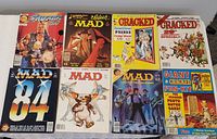 Lot of 8 vintage magazines including Mad, Cracked, and Savage titles, showing full covers arranged side by side on a gray surface.