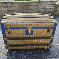 Front view showing woven wicker exterior, blue wooden trim, brass hardware, and monogram 'VGA'