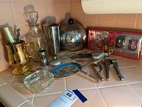 Overview of vintage barware and kitchen items including ice bucket, cocktail shaker, pitcher, ashtrays, corkscrew, and decorative tray.