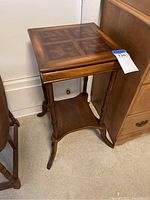 Full view of wooden end table showing legs, shelf, and top surface with tag