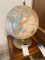 Full view of vintage globe showing Africa, Europe and parts of Americas with scratches on surface.