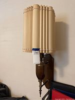 Full view of the vintage wall lamp showing the wooden pleated shade, brass fixture, and wooden backplate mounted to the wall.