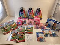 Set of 20 small toys in original packages including Disney Mickey, Barbie, Trolls, and Finding Nemo.